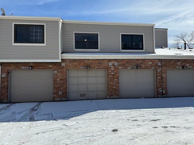 exterior space featuring a garage and brick siding