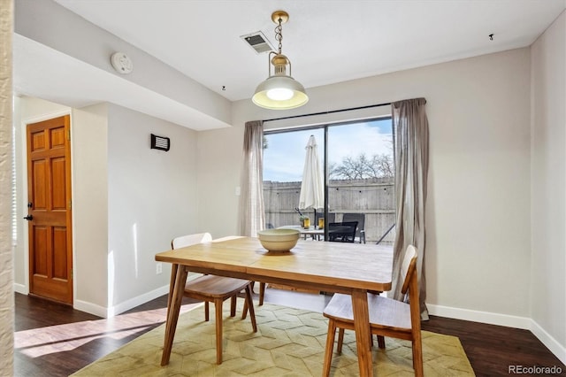 dining space featuring wood finished floors, visible vents, and baseboards