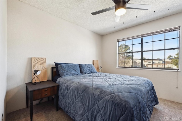 bedroom with a textured ceiling, ceiling fan, and carpet