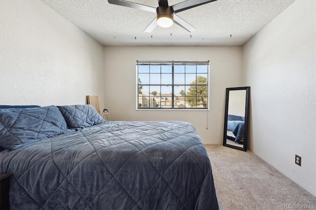 carpeted bedroom with ceiling fan and a textured ceiling