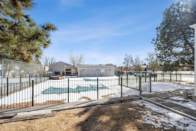 snow covered pool with a patio area, a fenced in pool, and fence