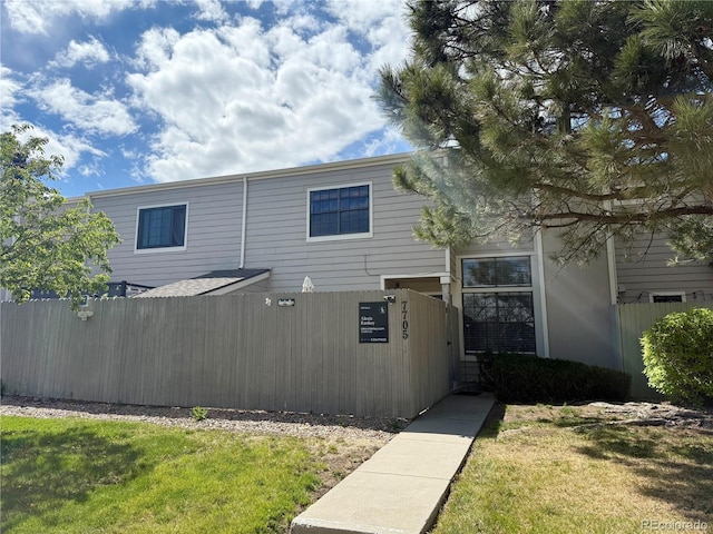 view of front of house featuring a front lawn and fence private yard