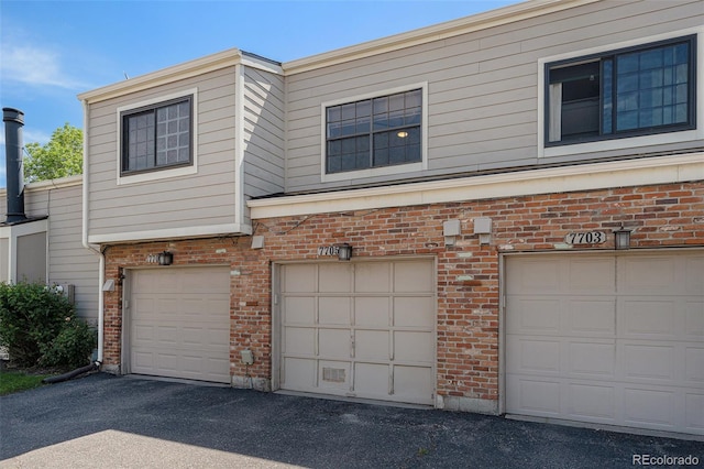 7705 W 87th Dr, Arvada, CO 80005 - view of front of house featuring brick siding and an attached garage