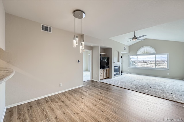 unfurnished living room with hardwood / wood-style flooring, ceiling fan, and vaulted ceiling