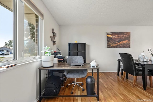 office featuring baseboards, wood finished floors, and a textured ceiling