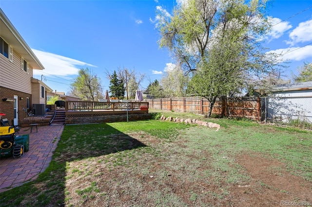 view of yard with a wooden deck, a fenced backyard, cooling unit, and a patio