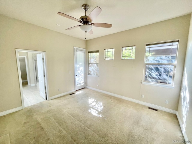 unfurnished bedroom with ceiling fan, ensuite bathroom, and light carpet