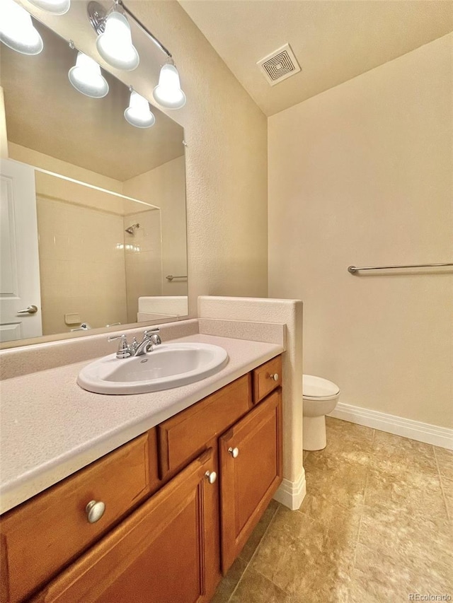 bathroom with walk in shower, vanity, and toilet