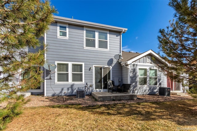 rear view of property featuring a lawn, central AC, and a patio area