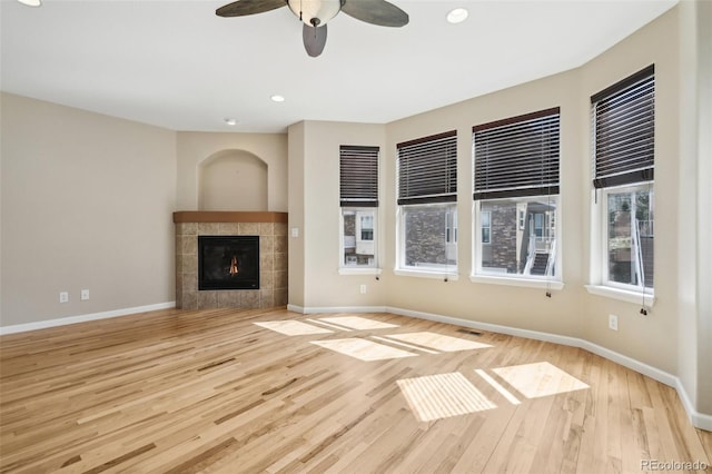 unfurnished living room featuring a fireplace, recessed lighting, baseboards, a ceiling fan, and wood finished floors