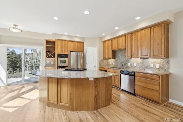 kitchen featuring open shelves, a sink, light wood finished floors, and stainless steel appliances