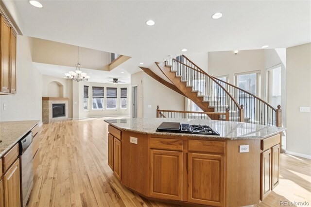 836 Vernon Dr, Central City, CO 80427 - kitchen featuring black gas cooktop, light wood-style flooring, a tile fireplace, stainless steel dishwasher, and a kitchen island