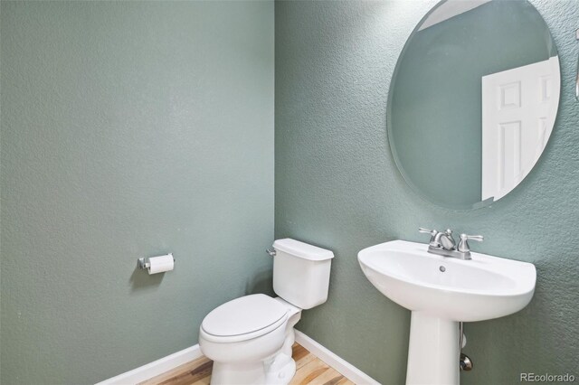 836 Vernon Dr, Central City, CO 80427 - half bathroom with a sink, baseboards, toilet, and wood finished floors
