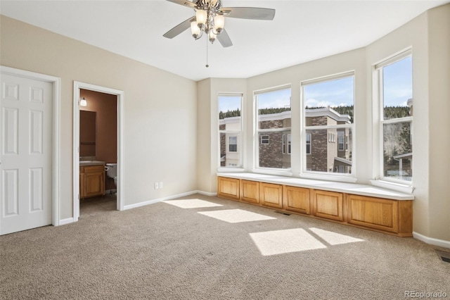 empty room featuring a ceiling fan, baseboards, light colored carpet, and visible vents