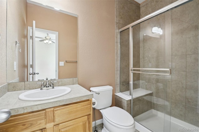 full bath featuring vanity, a ceiling fan, a shower stall, and toilet