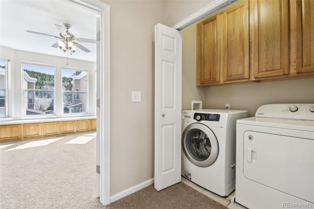 washroom with cabinet space, washer and dryer, light colored carpet, a ceiling fan, and baseboards