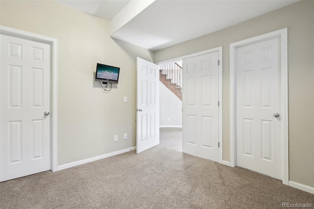 unfurnished bedroom with baseboards and carpet flooring