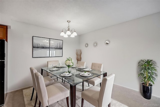 dining space with a chandelier, light colored carpet, and baseboards