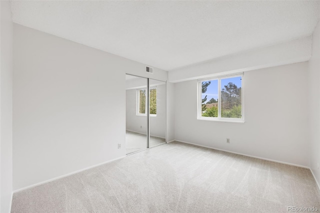 unfurnished bedroom with carpet floors, baseboards, and a closet
