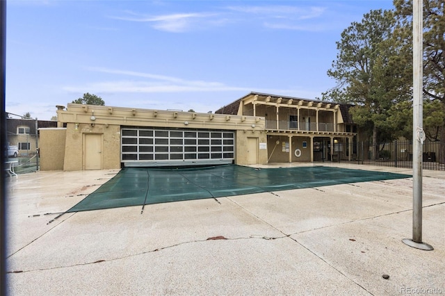 community pool with a patio and fence