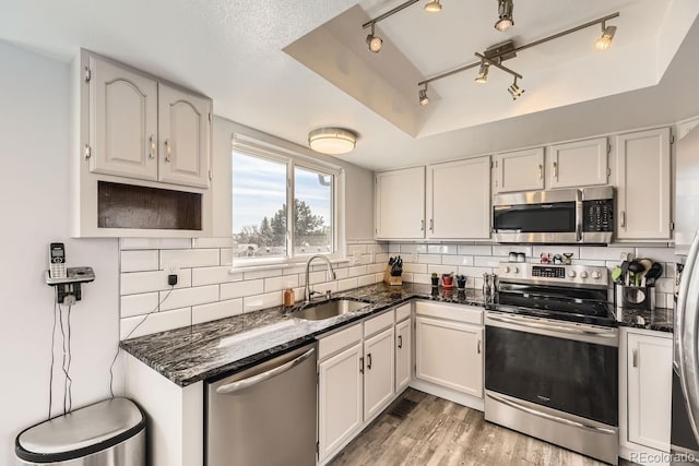 kitchen featuring dark stone countertops, sink, stainless steel appliances, and white cabinets