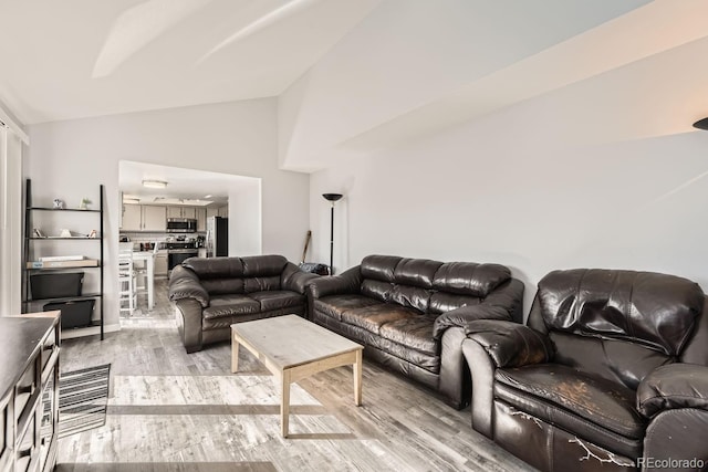 living room with high vaulted ceiling and light wood-type flooring