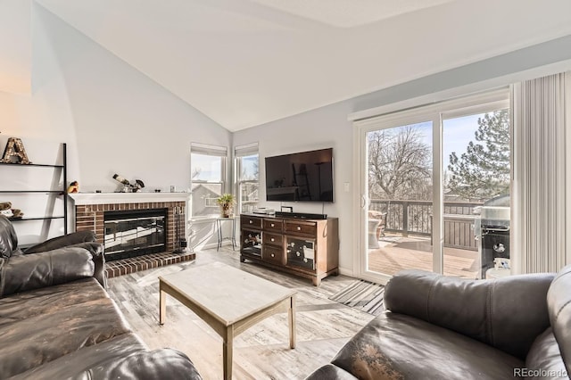 living room with plenty of natural light, lofted ceiling, and a fireplace