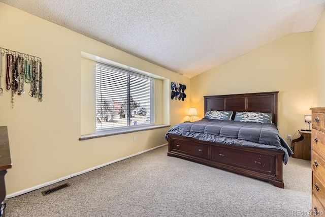 bedroom with vaulted ceiling, light carpet, and a textured ceiling