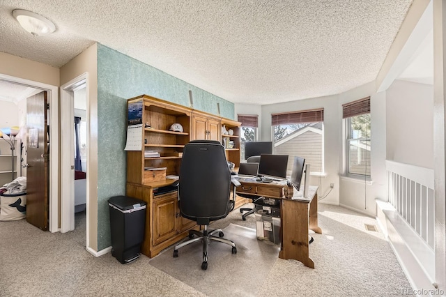 carpeted home office featuring a textured ceiling