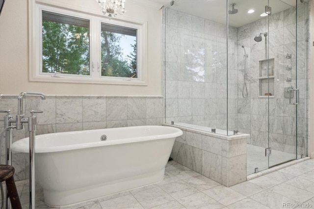 600 Vine St, Denver, CO 80206 - full bath featuring tile walls, a stall shower, a freestanding bath, marble finish floors, and wainscoting