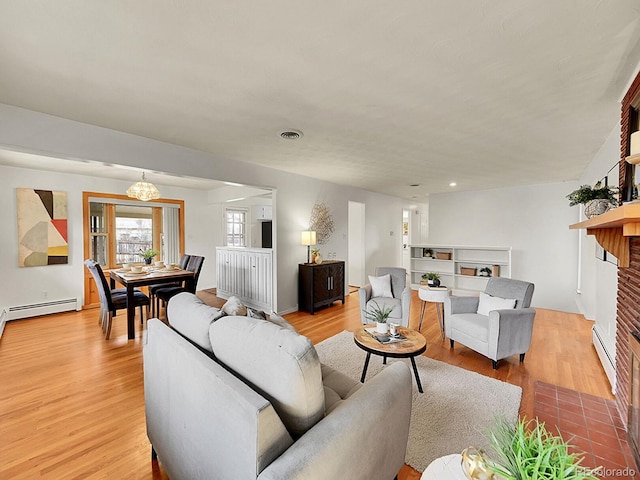 living room with light wood-type flooring, a fireplace, and baseboard heating