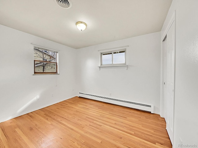 unfurnished room with light hardwood / wood-style floors and baseboard heating