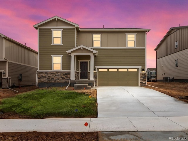 craftsman-style home featuring a garage, central AC, stone siding, driveway, and board and batten siding