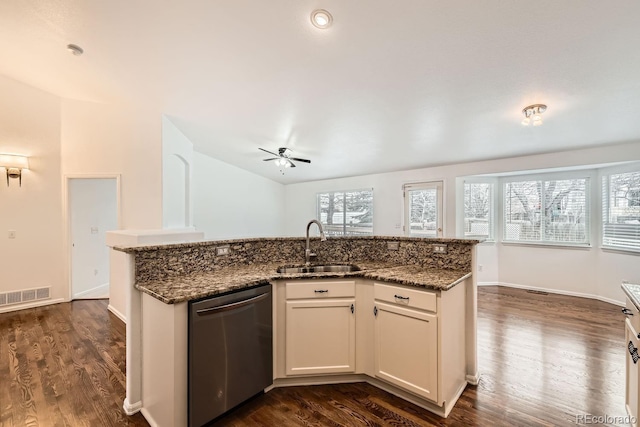 kitchen featuring sink, white cabinetry, dark stone countertops, plenty of natural light, and stainless steel dishwasher