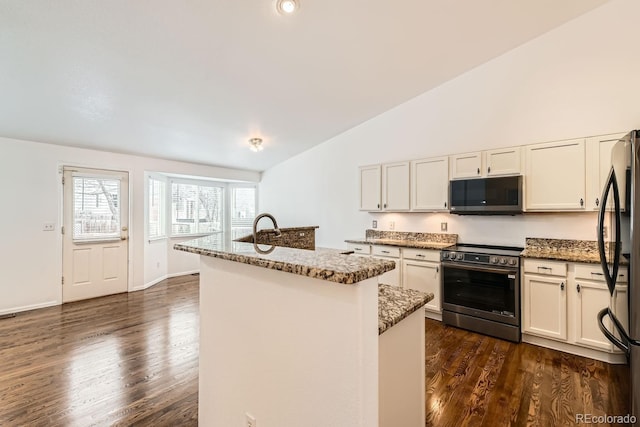 kitchen featuring black refrigerator, white cabinetry, electric range, light stone counters, and a center island with sink