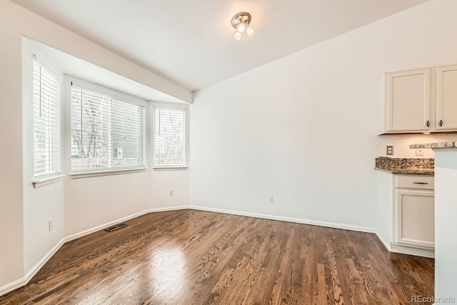 unfurnished dining area featuring dark wood-type flooring