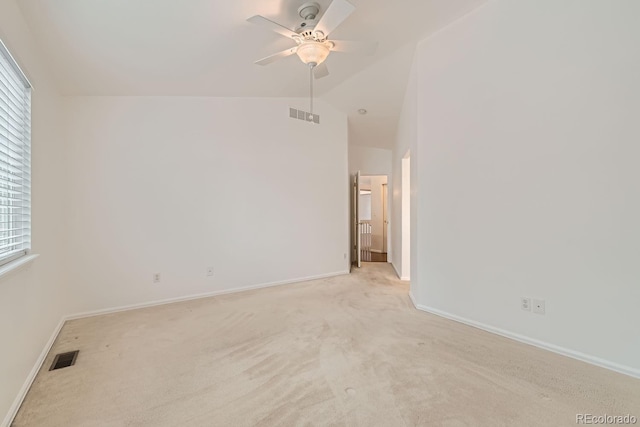 carpeted spare room featuring lofted ceiling and ceiling fan