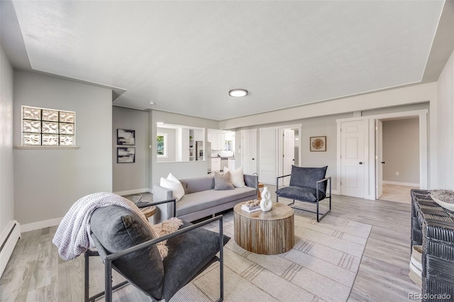 living room with light hardwood / wood-style floors and baseboard heating