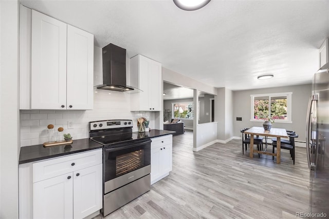 kitchen with white cabinetry, backsplash, stainless steel appliances, plenty of natural light, and wall chimney range hood