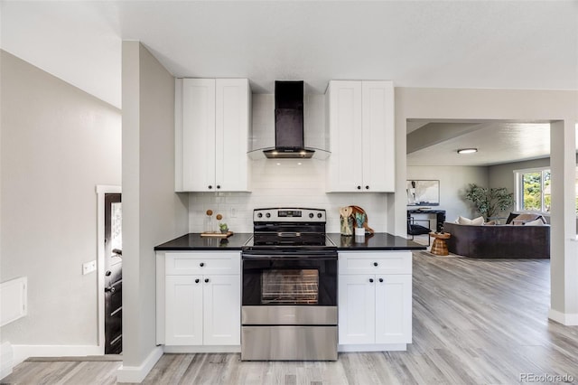 kitchen featuring white cabinetry, stainless steel electric range, light hardwood / wood-style flooring, and wall chimney exhaust hood