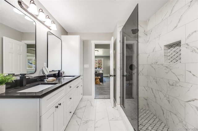 bathroom featuring tiled shower and vanity