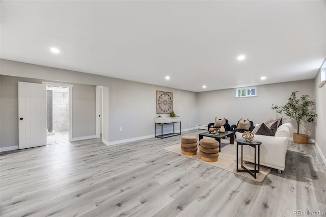 living room featuring a baseboard heating unit and light hardwood / wood-style floors