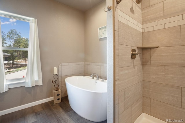 bathroom featuring wood finished floors, a tile shower, and a soaking tub