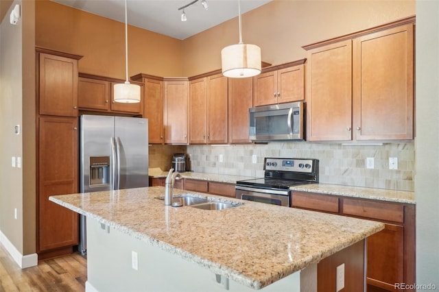 kitchen featuring sink, a center island with sink, decorative light fixtures, and appliances with stainless steel finishes