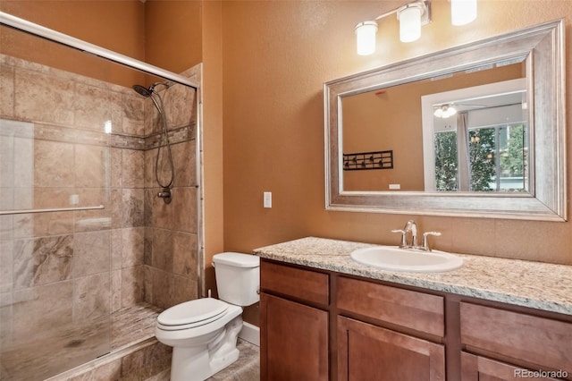 bathroom featuring vanity, toilet, and tiled shower