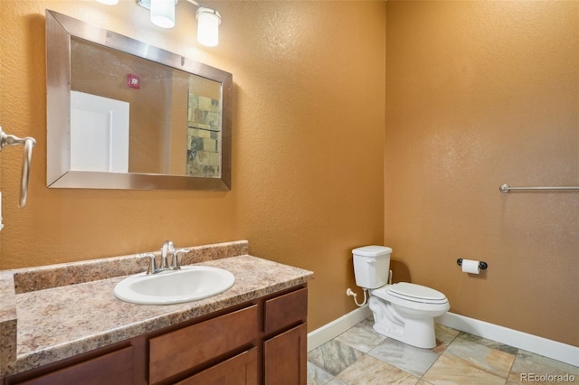 bathroom featuring toilet, vanity, and tile patterned flooring