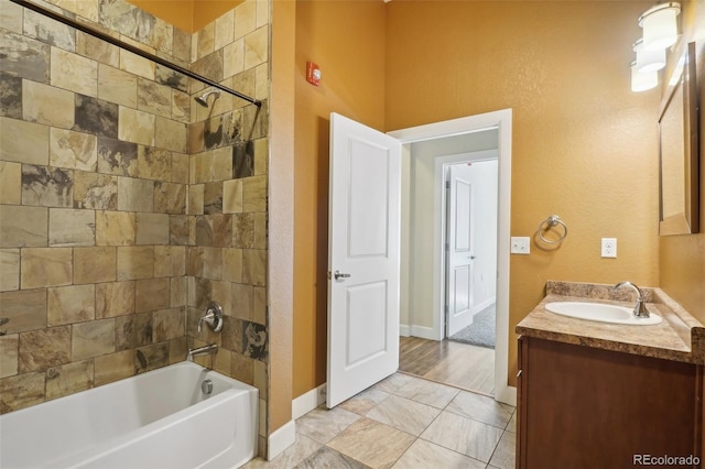 bathroom featuring tiled shower / bath and vanity