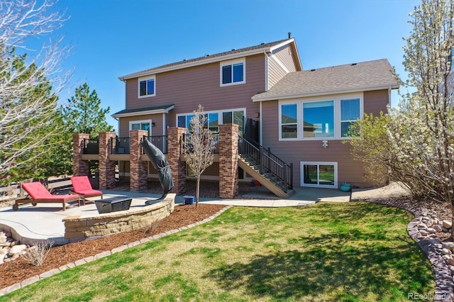 back of property featuring a lawn, an outdoor fire pit, a patio area, stairs, and a deck