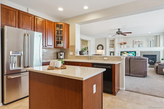kitchen with a center island, stainless steel refrigerator with ice dispenser, dishwasher, a sink, and a peninsula