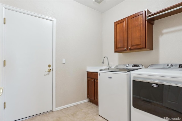 laundry area featuring separate washer and dryer, visible vents, a sink, baseboards, and cabinet space